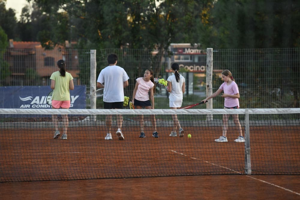 Niña con raqueta en una cancha de tenis